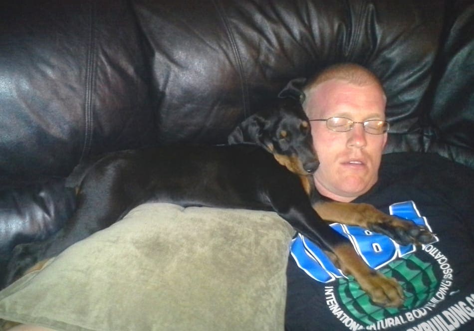 Slapende Doberman pup met zijn baasje.
