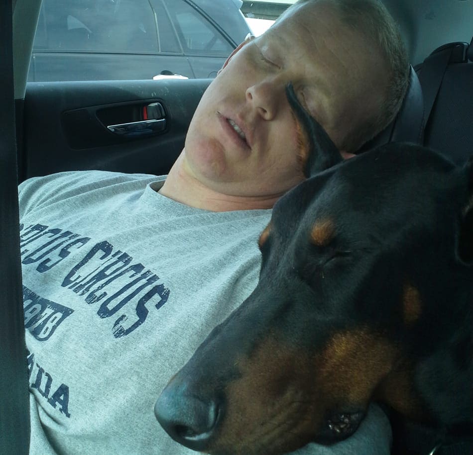 Ik slapend in de auto met mijn Doberman Cooper.